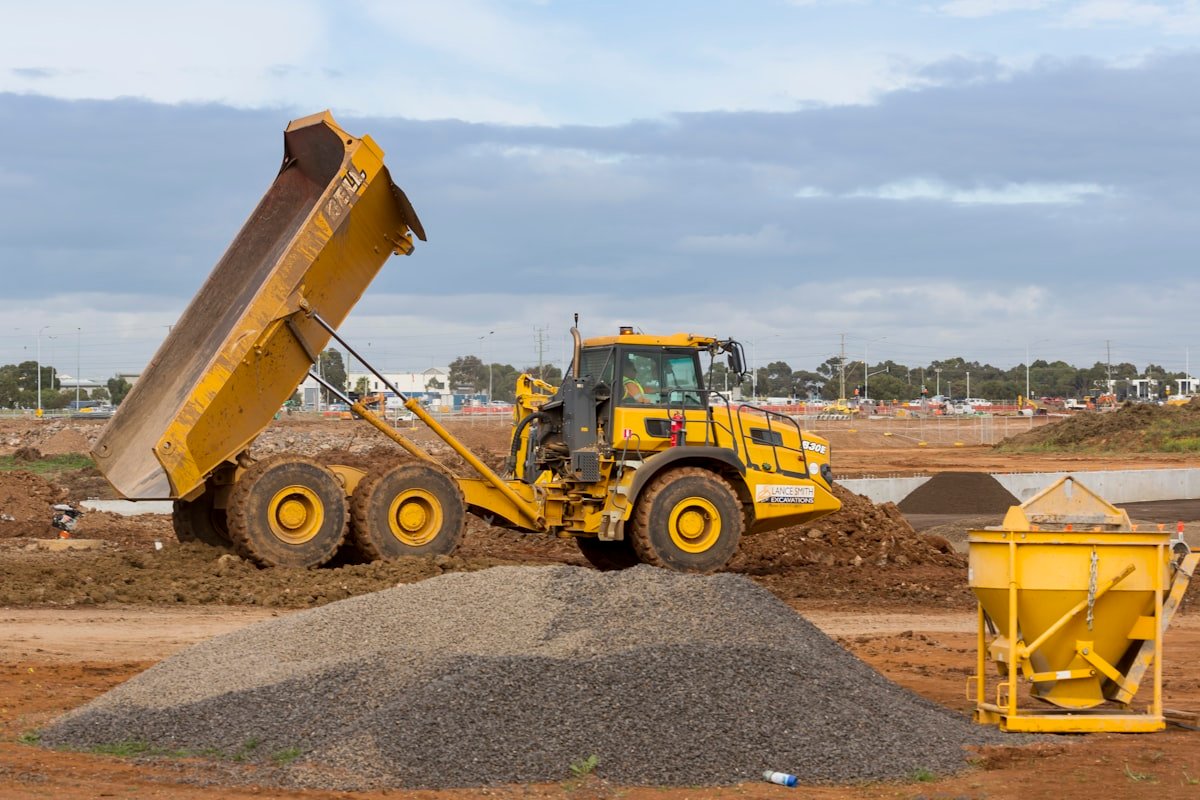 Articulated dump truck unloading gravel on site